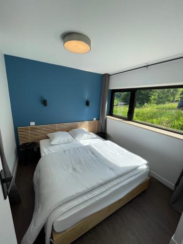 勒蒙多尔L'Ecrin d'Edern 4pers Mont Dore的一间卧室设有一张床和一个大窗户