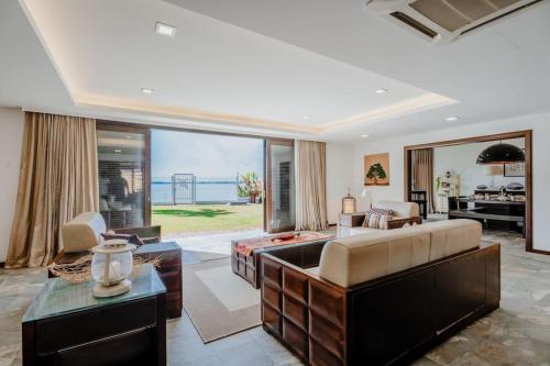 波德申Bamboo Rimbun-Tranquil Seaside Villa, Port Dickson的带沙发和大窗户的客厅