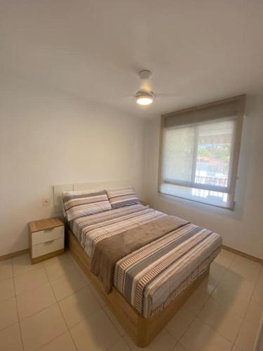 贝尼卡西姆Apartamentos Cumbremar en Benicàssim的一间卧室配有一张床,房间设有窗户