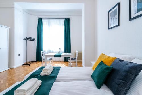 布达佩斯Budafoki Residence的卧室配有一张带彩色枕头的大型白色床。