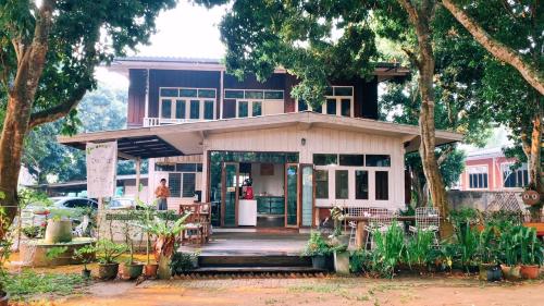 Kampong HuaibūYor Song Hostel Pai的房屋设有门廊和桌椅