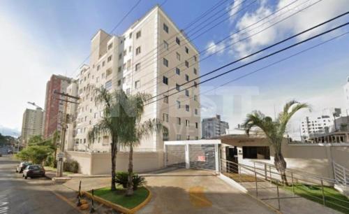 戈亚尼亚Apartamento Aconchegante的一座棕榈树城市中的白色大建筑