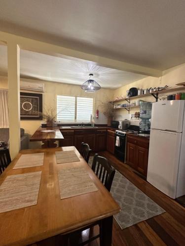 库尔克岛The Coral Casa的厨房配有桌子和白色冰箱。