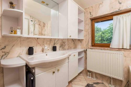 奥帕提亚Villa The Nest的白色的浴室设有水槽和窗户。