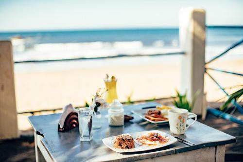 拉斯彭尼塔斯Casita de Playa BOMALU的海滩上一张桌子,上面放着两盘食物