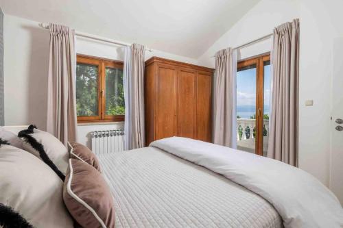 奥帕提亚Villa The Nest的一间卧室设有一张床和一个大窗户