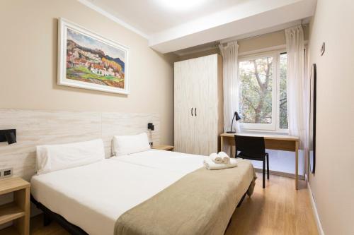 巴塞罗那AB Eixample Viladomat的一间卧室配有一张床、一张书桌和一个窗户。