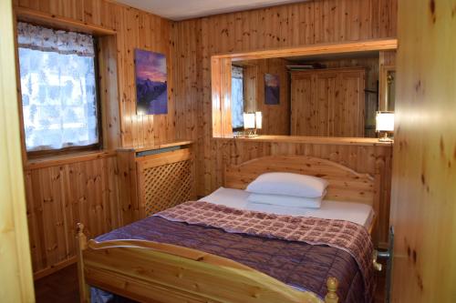 卡纳泽伊Arnica的木制客房内的一间卧室,配有一张床