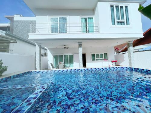 南芭堤雅Relax Pool Villa Near Walking Street,jacuzzi ,BBQ 5Bed 6Bath City house54的房屋前有游泳池的房子