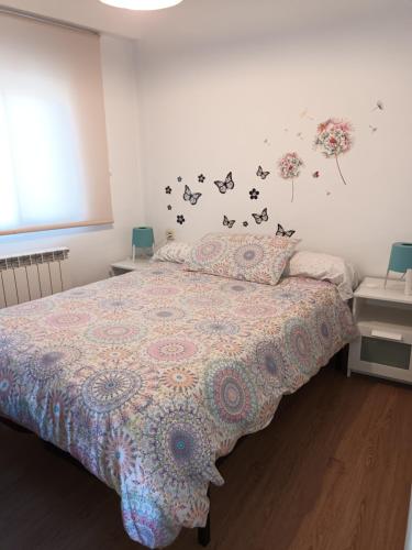 马德里卡拉班切卡斯蒂佐公寓的一间卧室配有一张带花卉床罩的床