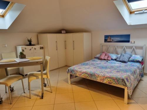 斯波托尔诺La Mansarda di Noi2的卧室配有一张床和一张桌子及椅子