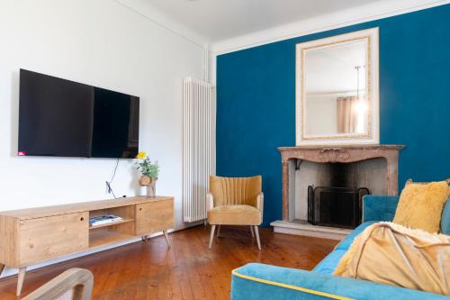 布里萨戈Palazzo Branca - Unique experience的客厅配有电视和蓝色的墙壁