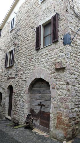 MontecchioCasa Momo的一座古老的石头建筑,设有门窗