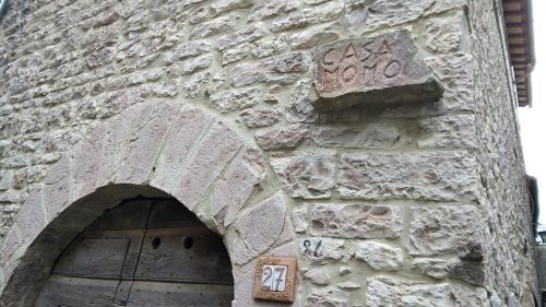 MontecchioCasa Momo的石头建筑,有门,上面有标志
