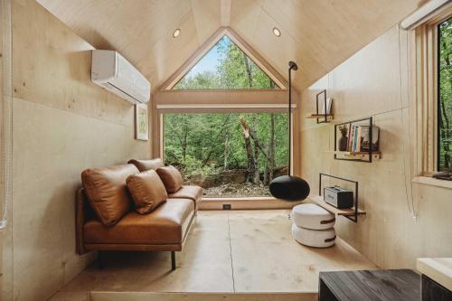 伍德斯托克Lumen Nature Retreat的带沙发和大窗户的客厅