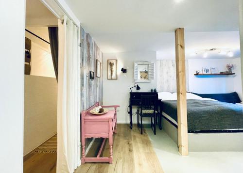 特里尔Ferienwohnung Berg&Tal - Naturnah的一间卧室配有粉红色的桌子、一张床和一张书桌