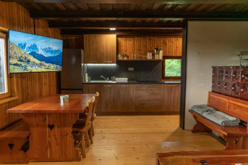 韦莱涅VILA HELENA的厨房配有木桌和大屏幕