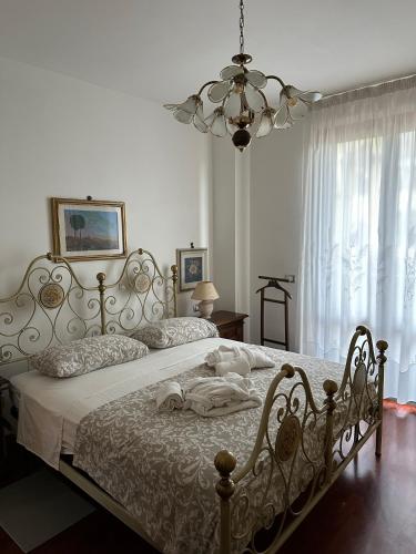 圣多尼诺Casa Maria (posto auto gratuito)的卧室配有一张带吊灯的大型白色床。