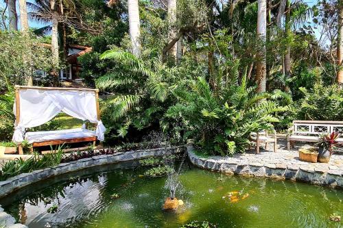 布希奥斯Taman Búzios Hotel的花园内有一个池塘,里面放着风筝