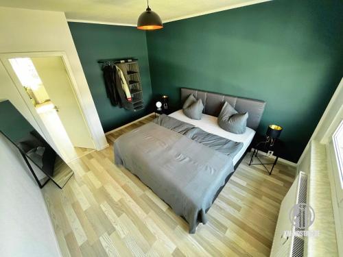 开姆尼茨KMHosting Luxe Apartment Chemnitz-Zentrum的一间卧室设有一张床和绿色的墙壁