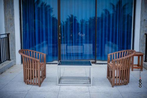 卡尔库达Aqua Marine Beach Hotel的窗前的两把椅子和一张桌子