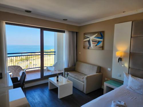 亚实基伦Tamara Ashkelon Hotel的酒店客房设有床、沙发和阳台。