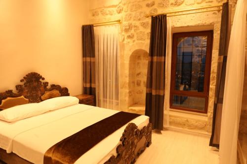 马尔丁Mardin Bey Konağı Hotel的一间卧室设有一张床和一个窗口