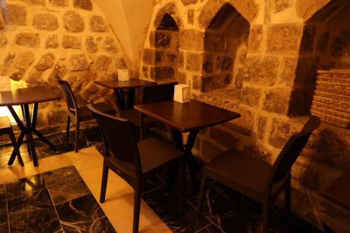 马尔丁Mardin Bey Konağı Hotel的石墙内带桌椅的餐厅