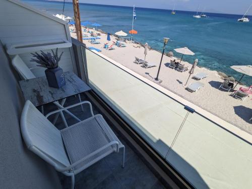卡尔扎迈纳Pillbox Seafront Studios and Apartments的阳台上的椅子,俯瞰着海滩