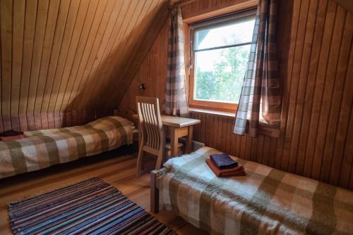 Sõru普瑞丽假日农场的客房设有两张床、一张桌子和一扇窗户。
