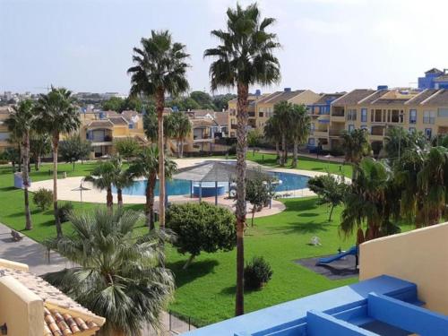 埃尔韦尔赫尔appartement bord de mer 15 mn de Dénia的享有带游泳池和棕榈树的度假村景色