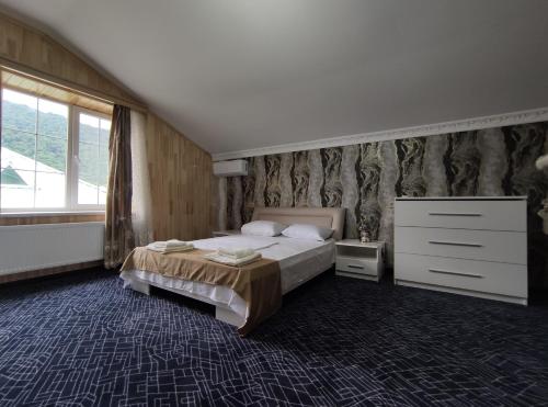盖贝莱Voyage Gabala的一间卧室配有一张床、一个梳妆台和一扇窗户。