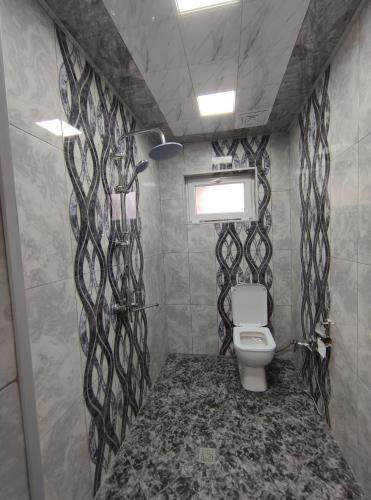 盖贝莱Voyage Gabala的浴室设有卫生间,配有黑色和白色图案的墙壁