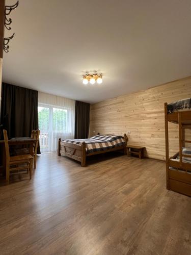 米库利钦Кам'яний двір的一间卧室设有一张床和木墙