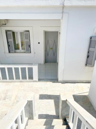 波西多尼亚Poseidonia's Breeze的门前有两长椅的白色房子