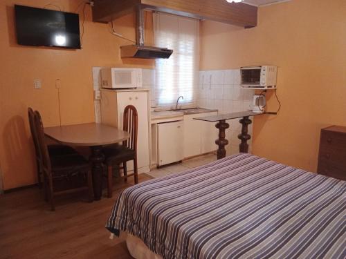 维纳德马Aquamarina Apart Hotel的配有床和桌子的房间以及厨房