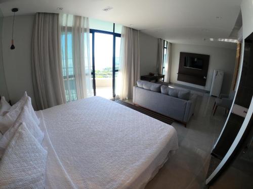 马瑙斯Tropical Executive Hotel的卧室配有一张白色的大床和一张沙发。
