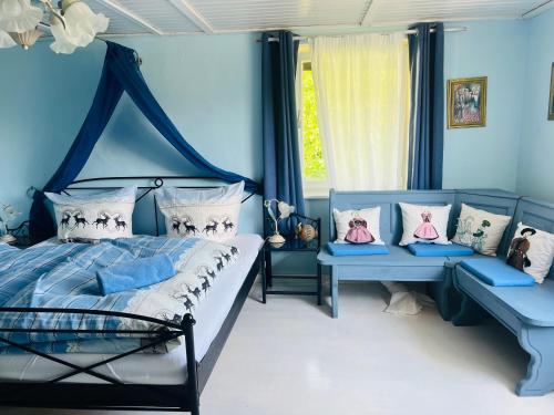 FinningCharming historical farmhouse的一间蓝色卧室,配有床和两张长椅