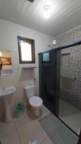 萨纳Pousada Sítio Val Paraíso的浴室配有卫生间、淋浴和盥洗盆。