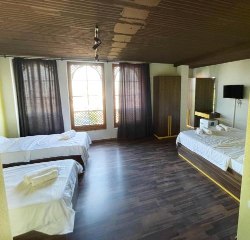 普里兹伦Hotel Hiserra的酒店客房设有两张床和电视。