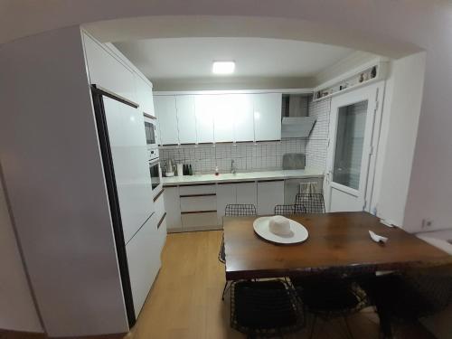 艾登Villa suzi的厨房配有木桌和白色冰箱。