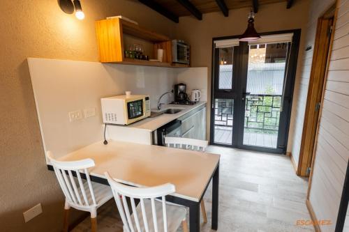 拉安戈斯图拉镇Departamento Lake Soul Villa La Angostura的一间带桌子和微波炉的小厨房