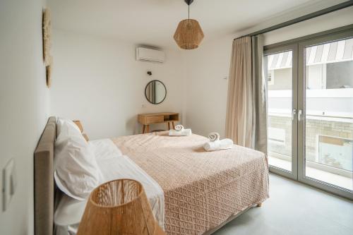 卡尔扎迈纳Sandy feet comfort suite的白色的卧室设有床和窗户