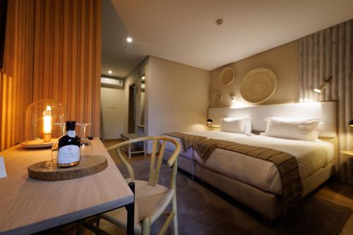 阿马马尔佛尔哥萨多罗酒店的酒店客房,配有一张床和一张桌子,并备有一瓶葡萄酒