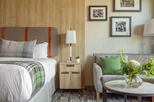 因弗米尔Headwaters Lodge at Eagle Ranch Resort的一间卧室配有一张床、一把椅子和一张桌子