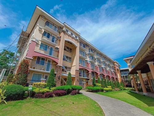 达沃市Italian Inspired Condo in Davao by AAG的一座大型公寓楼,前面设有花园