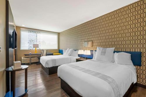 萨凡纳GLo Best Western Pooler - Savannah Airport Hotel的酒店客房配有两张床和一张书桌