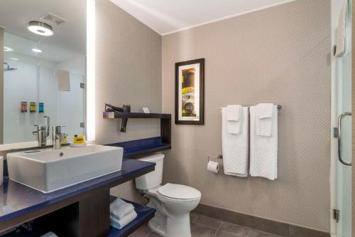 萨凡纳GLo Best Western Pooler - Savannah Airport Hotel的一间带水槽、卫生间和镜子的浴室