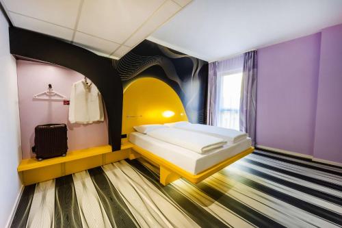 波恩prizeotel Bonn-City的紫色墙壁客房里一间卧室,配有一张床