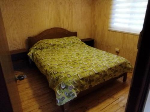 瓦尔帕莱索Cabaña laguna los patos的一间卧室配有一张带绿色棉被的床